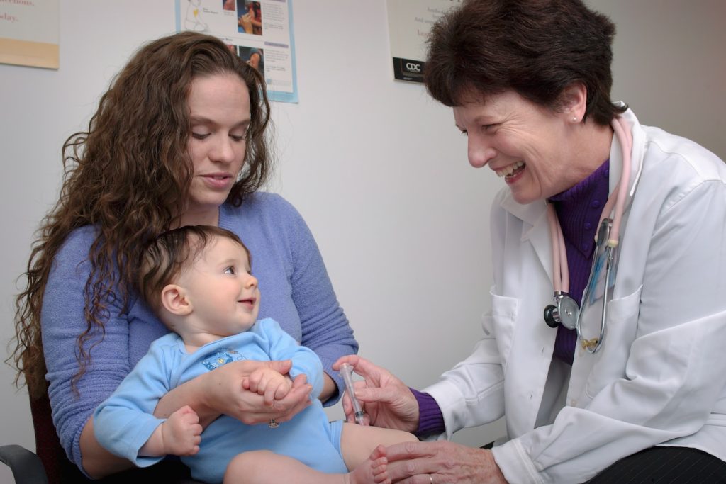 A paediatrician giving a baby a vaccine injection